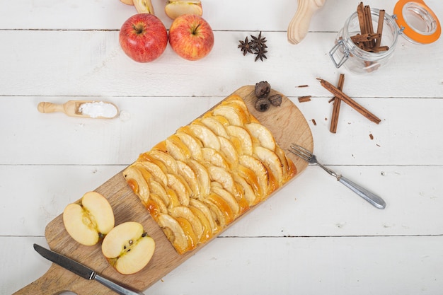 Tarta de manzana con masa brioche sobre tabla para cortar madera. Vista superior.