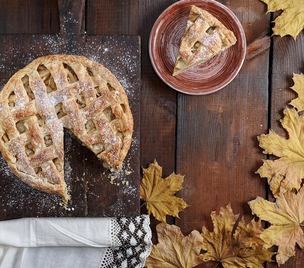 Tarta de manzana redonda al horno y una pieza cortada en un plato