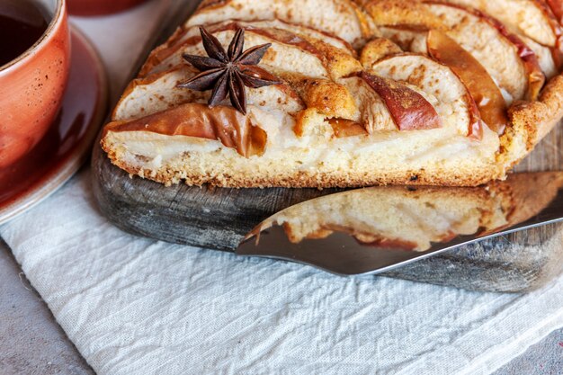 Tarta de manzana, taza de té aromático, anís y cuchillo de corte