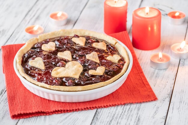 Tarta de mermelada de cereza decorada con corazones, con velas encendidas