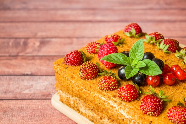 Tarta de miel con fresas, menta y grosellas.