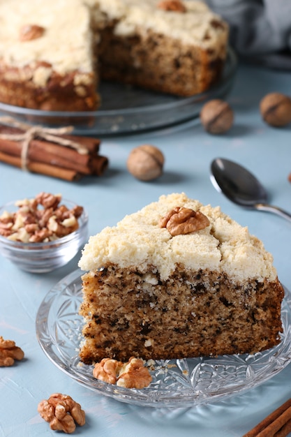 Tarta de migas casera con nueces y canela en placa sobre fondo azul claro