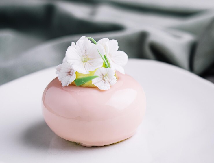 Tarta mousse rosa decorada con flores blancas