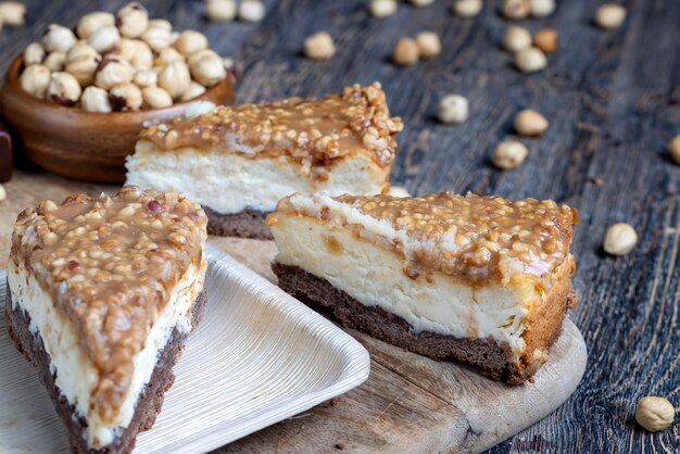 Tarta multicapa hecha de tarta de chocolate, tarta de queso con leche y caramelo suave con cacahuetes, tarta dulce y deliciosa con nueces y caramelo