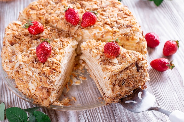 Tarta de Napoleón en rodajas sobre una mesa de madera blanca. Postre clásico