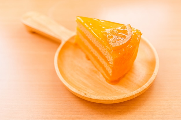 Tarta de naranja dulce postre en plato de madera sobre mesa de madera