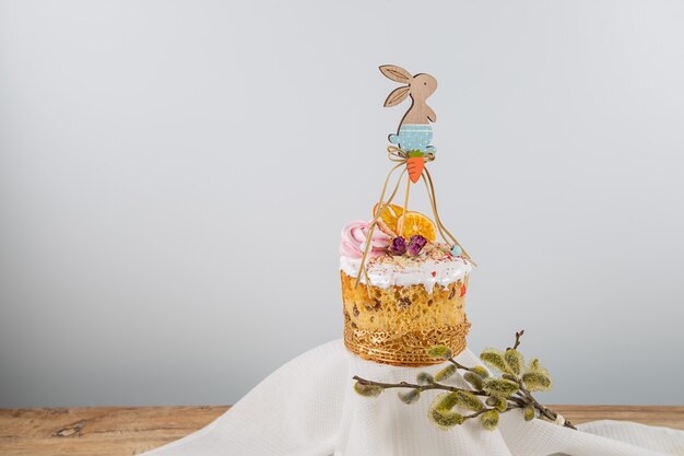 tarta de pascua con adornos de madera decorativos en forma de conejo, naranjas secas