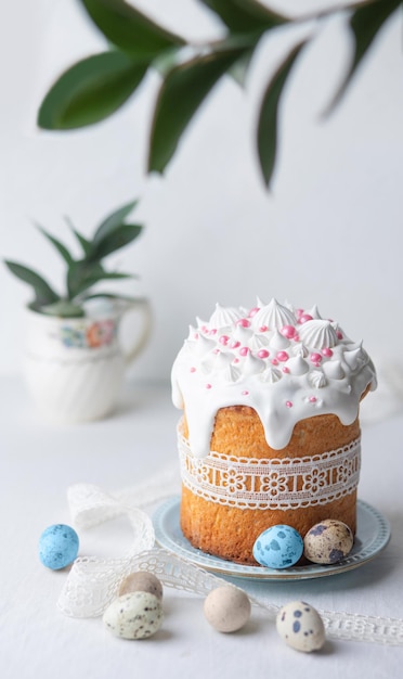 Tarta de Pascua casera tradicional decorada con espolvorines de pastelería glaseada y cinta de encaje en un pl azul