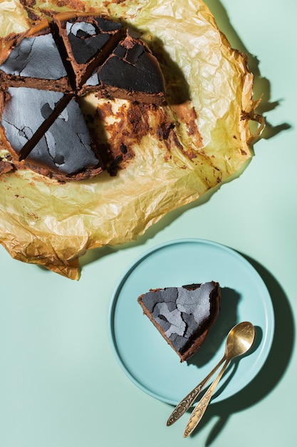 Tarta quemada casera vasca, Cheesecake de chocolate al estilo neoyorquino con corteza agrietada. Comida local de moda de San Sebastián, España. Fácil para cocinar en casa. Luz dura y sombras