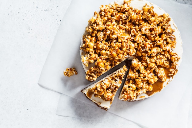 Tarta de queso de anacardo vegano crudo con palomitas de caramelo, vista superior, concepto de postre vegano crudo,