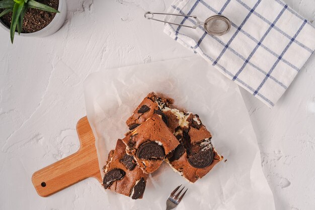 Foto tarta de queso brownie casera sobre una tabla de madera y pergamino