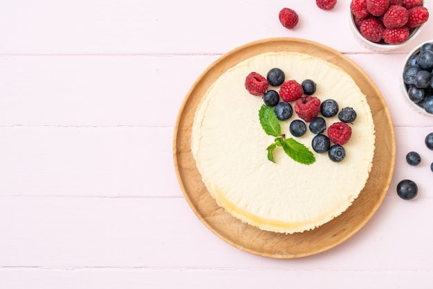 Tarta de queso casera con frambuesas y arándanos.