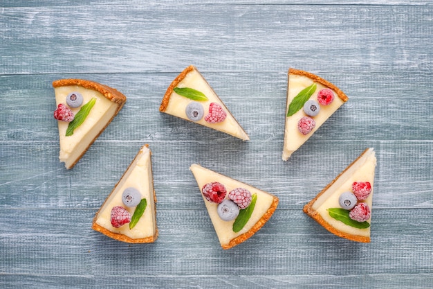 Tarta de queso casera de Nueva York con bayas congeladas y menta, postre orgánico saludable, vista superior