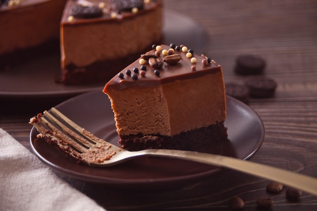 Tarta de queso y chocolate en la mesa de madera con un tenedor.