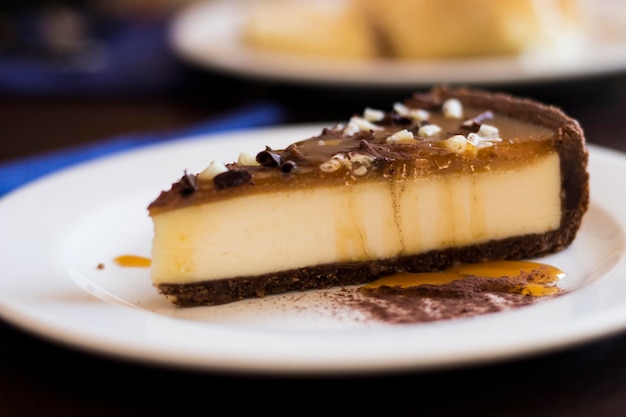 Tarta de queso con cobertura de caramelo y chocolate en un plato blanco