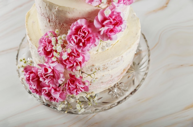Tarta de queso crema de boda en capas con flores de clavel