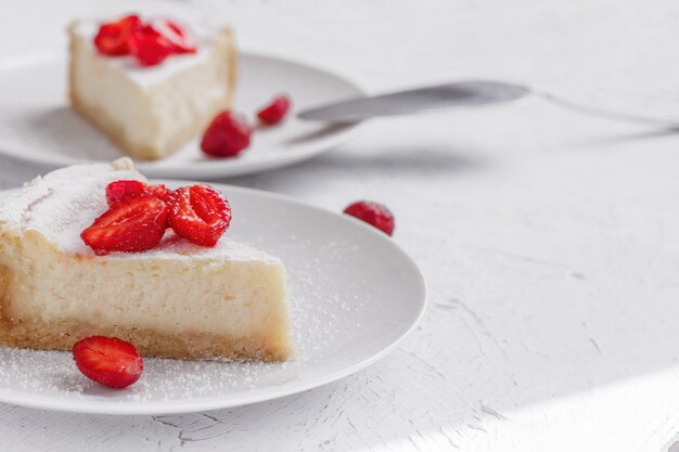 Tarta de queso decorado con fresas en un plato blanco