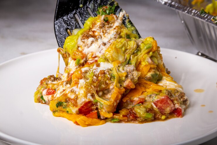 Foto tarta de queso, ensalada y carne servida en un gran bol, comida casera
