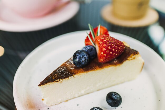 Tarta de queso de fresa quemada servida en la placa blanca.