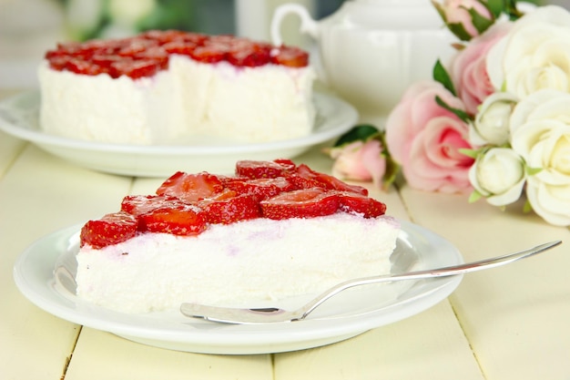 Tarta de queso con fresas frescas en un plato blanco sobre una mesa de madera