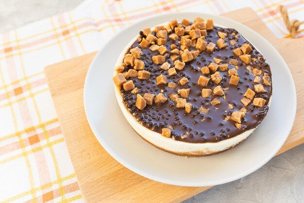 Tarta de queso con glaseado de chocolate y trozos de caramelo salado