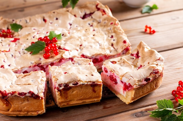 Tarta de queso de grosella roja con bayas frescas sobre mesa de madera