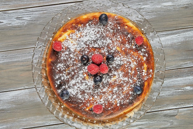 Tarta de queso sin masa con almíbar de frutos rojos y frambuesas y arándanos