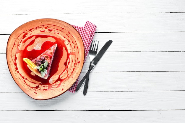 Tarta de queso con mermelada de cereza y cerezas en un plato Postre Sobre un fondo de madera Espacio de copia libre Vista superior