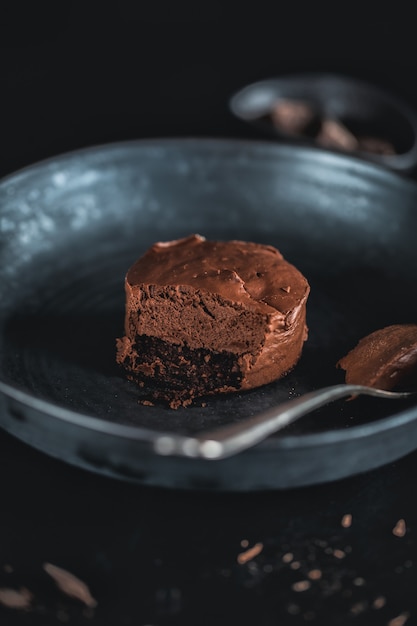 Tarta de queso muffin de chocolate en un plato oscuro con un tenedor