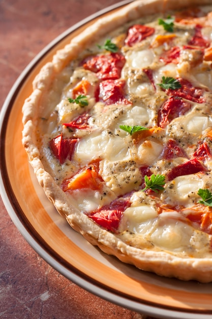 Tarta con queso de oveja salado y tomates