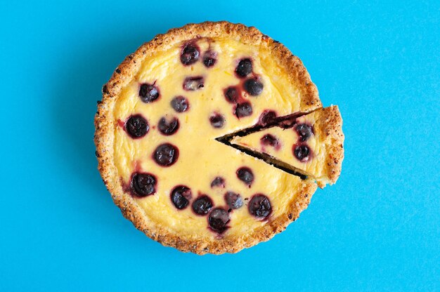 Tarta de queso ricotta en rodajas con cerezas sobre un fondo azul Vista superior Horneado abundante