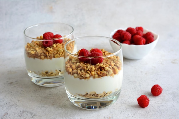 Tarta de queso saludable en vaso con frambuesa aislado sobre fondo concreto, primer plano