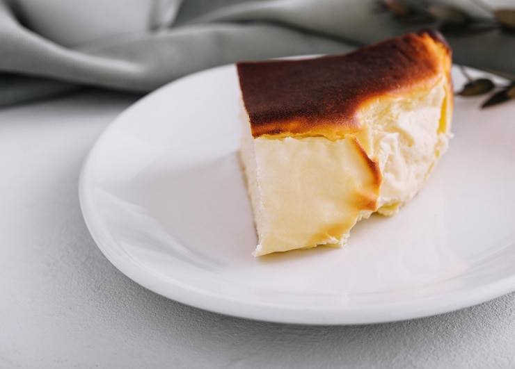 Tarta de queso san sebastián en plato con té