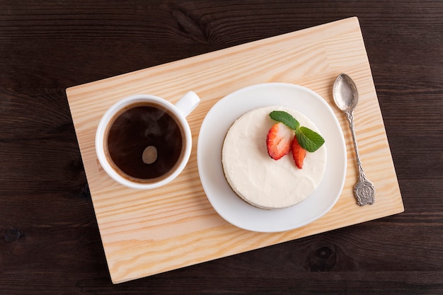 Tarta de queso y taza de café en bandeja de madera. Buen desayuno. Vista superior