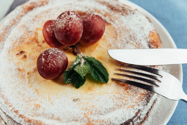 Tarta de queso tradicional cremosa fresca con uvas y wi espolvoreado