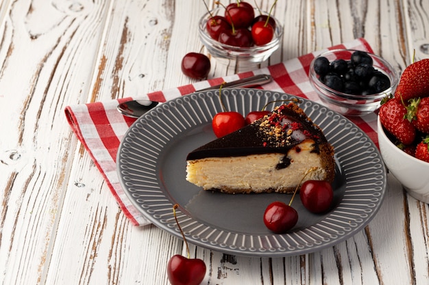 Tarta de queso de vainilla con cobertura de chocolate y frutos rojos frescos