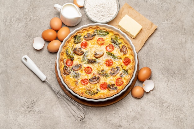 Tarta de quiche casera al horno en forma de cerámica para hornear, huevos y crema