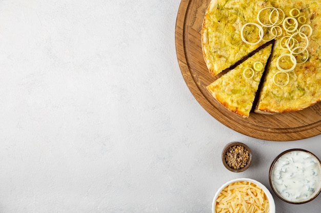 Tarta de quiche con puerro, patatas y queso plano sentar sobre fondo de hormigón gris con espacio de copia