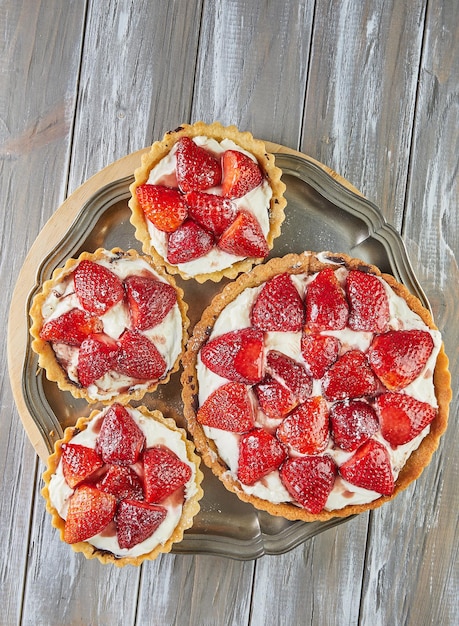 Tarta redonda de crema con fresas Una grande y tres pequeñas