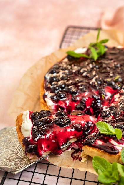 Tarta con relleno cremoso de queso crema o mascarpone con salsa de grosella negra y menta