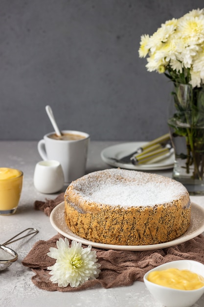 Tarta de semillas de amapola con azúcar en polvo, crema pastelera y una taza de café