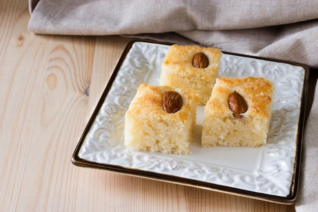 Tarta de sémola árabe tradicional Basbousa (namoora) con almendras y almíbar