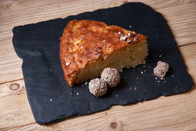 La tarta de tarta de manzana en tablero de pizarra con pasas, nueces y canela es una textura de fondo de madera vintage. Estilo rústico