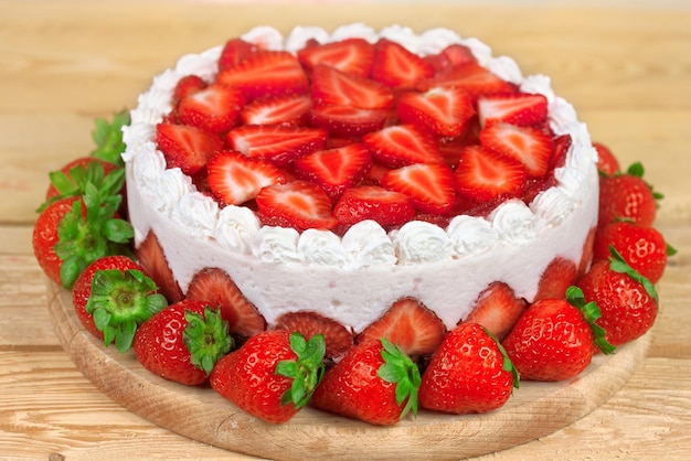 Tarta de yogur con fresas sobre mesa de madera