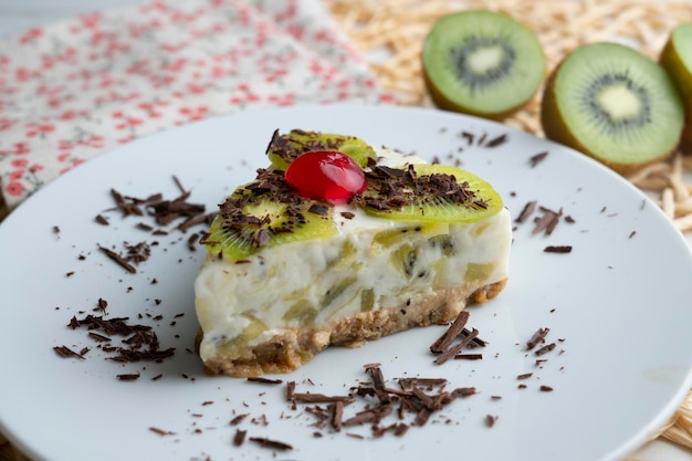 Foto tarta de yogur y kiwi con base de galleta decorada con chocolate rallado