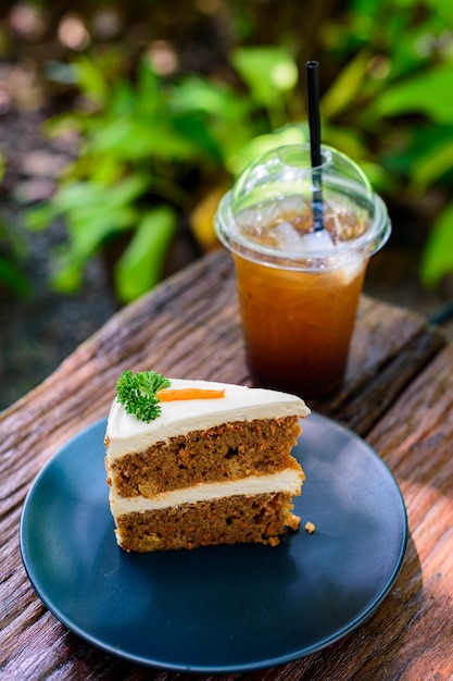 Tarta de zanahoria con café en una mesa de madera en el jardín