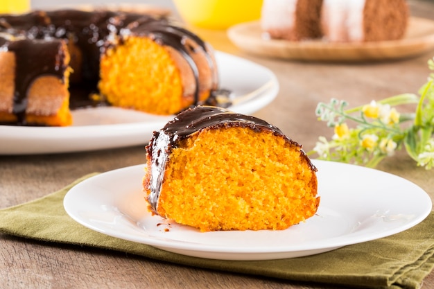 Tarta de zanahoria con chocolate y rebanada sobre la mesa.