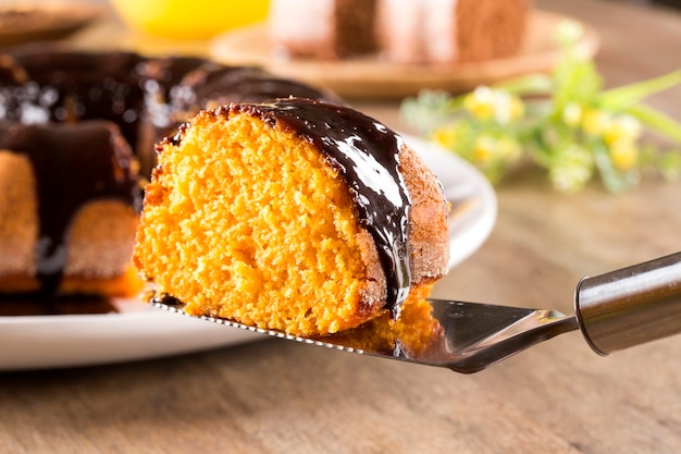 Tarta de zanahoria con chocolate y rebanada sobre la mesa.