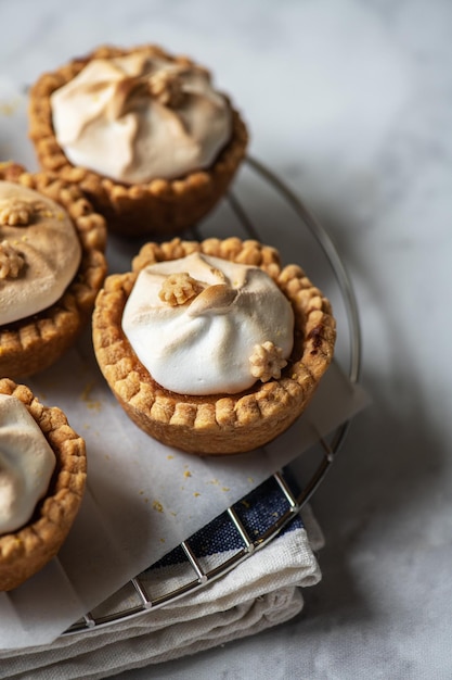 Tartaletas de cuajada de limón con merengue batido en una rejilla Cerrar