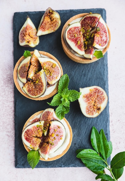 Tartaletas de hojaldre con crema blanca cubiertas con higos y pistacho Concepto de cocina Postre saludable